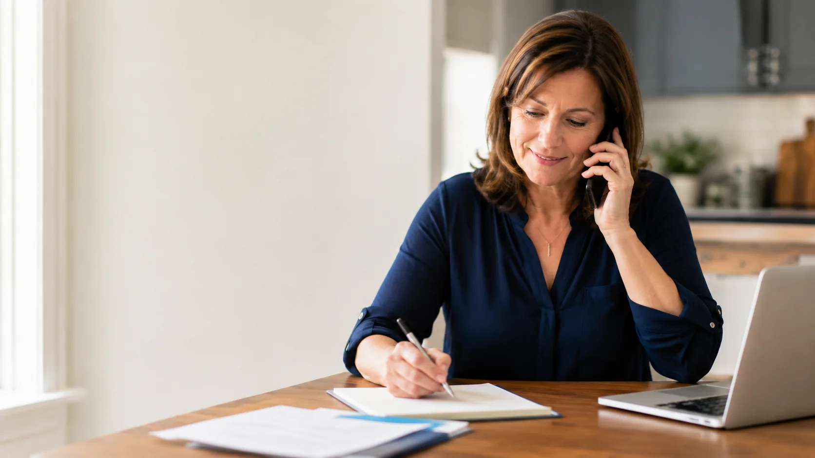A professional taking notes during a claimant phone consultation